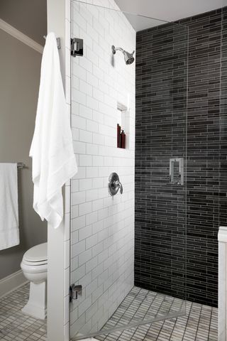 Jersey City apartment bathroom with white subway tile and dark glass mosaic shower wall